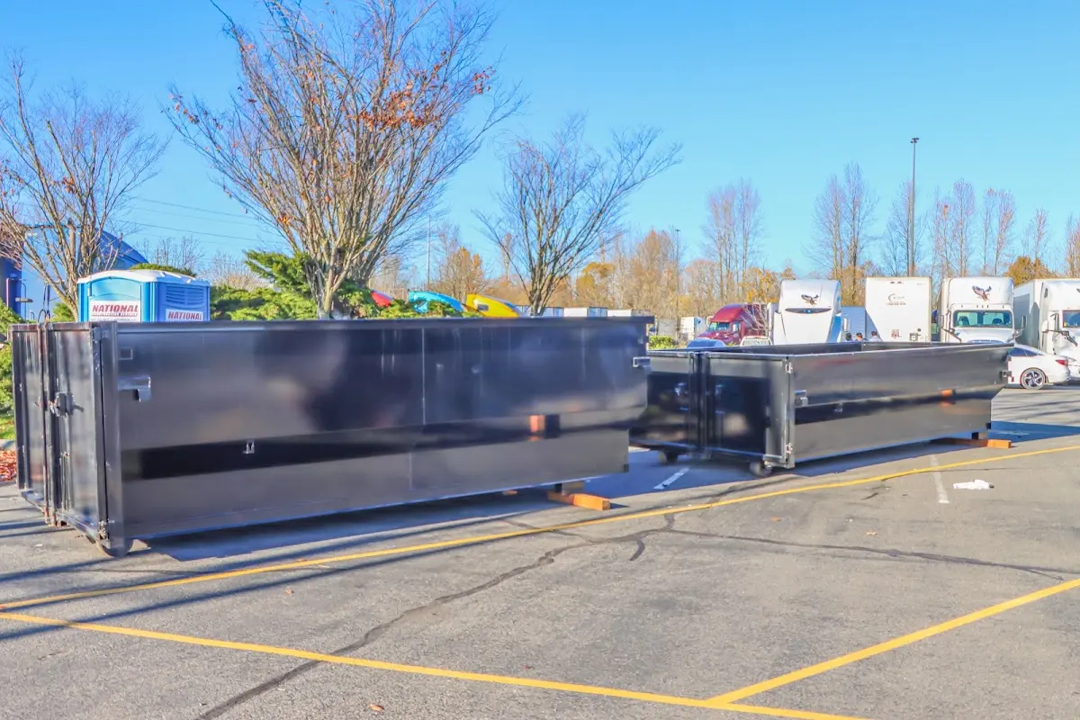 Professional dumpster rental service with roll-off container on residential driveway in Lansing